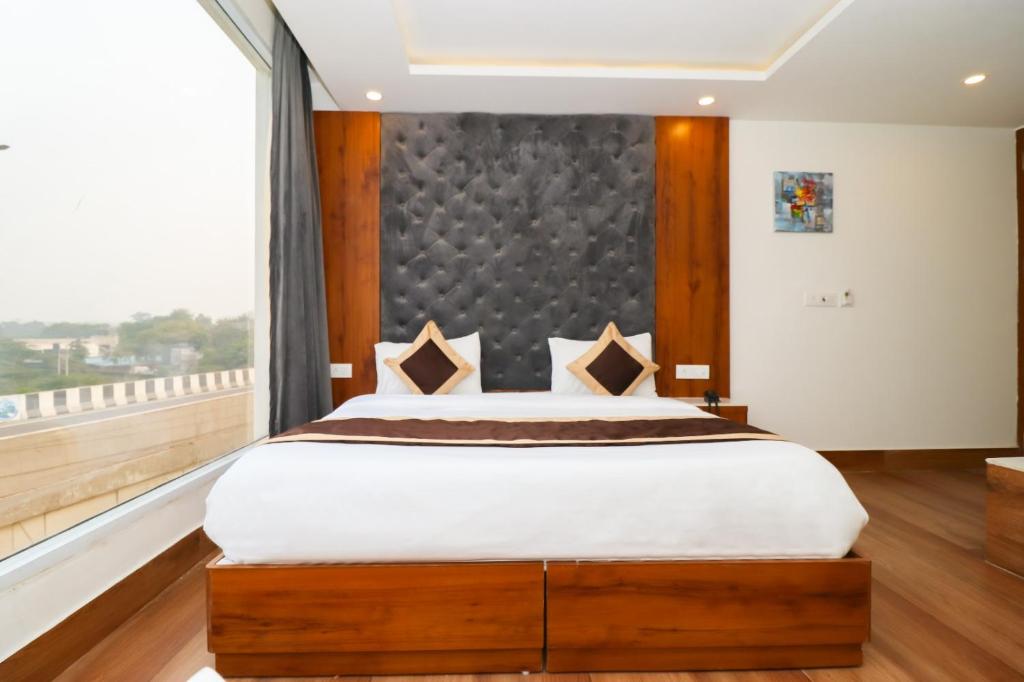 a bedroom with a large bed and a large window at Mukul inn in Gurgaon