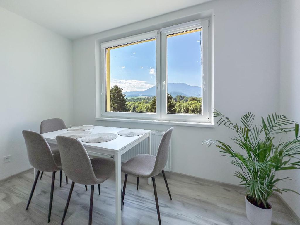 a white dining room with a table and chairs and a window at Apartmán/byt Liptovský Mikuláš in Liptovský Mikuláš