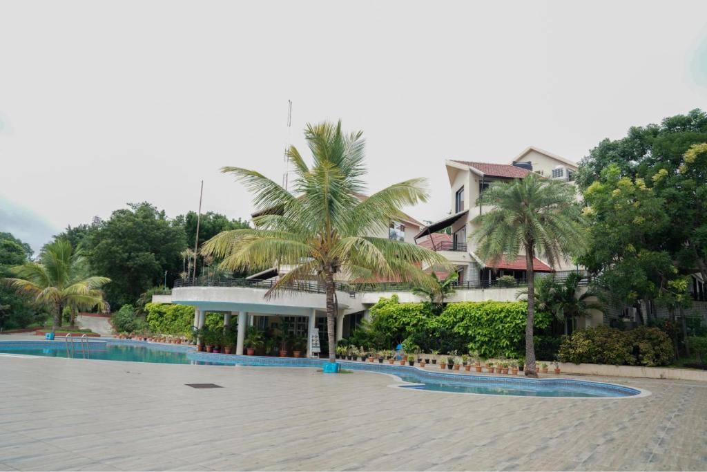a resort with palm trees in front of a building at Ctrl Alt Heal Sparsh Integrated Wellness Center in Hyderabad