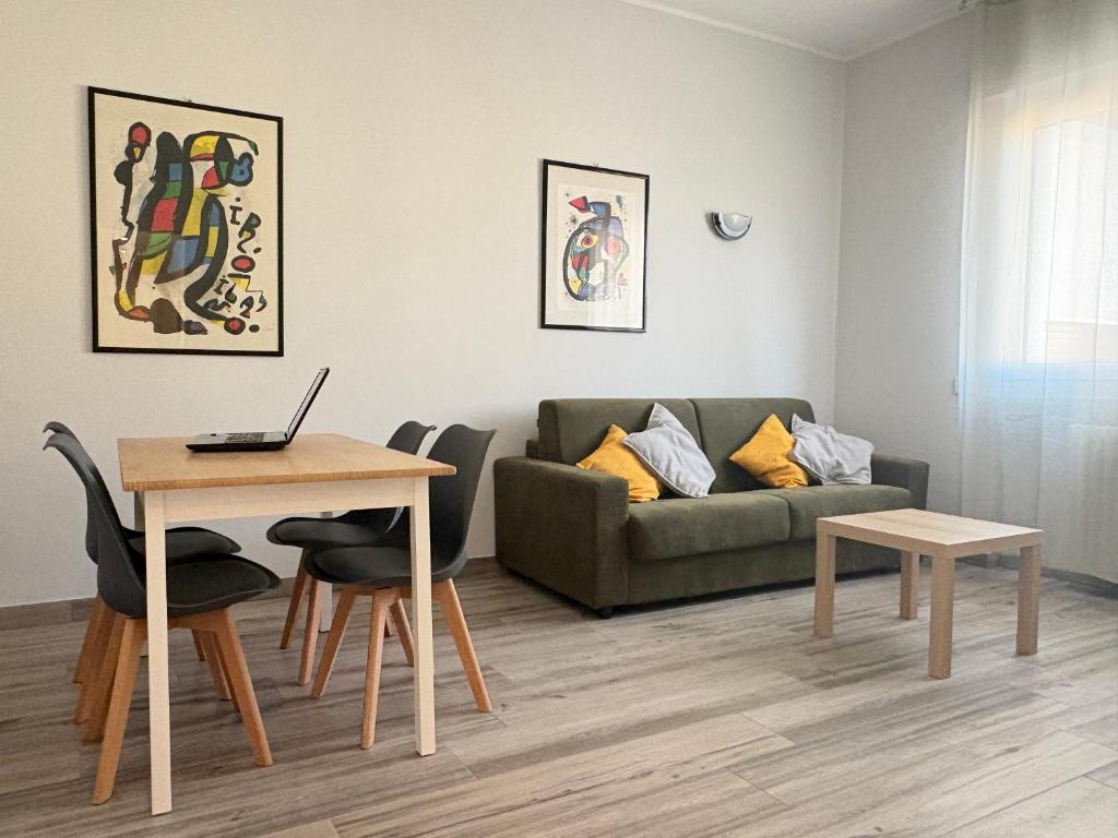 a living room with a couch and a table with a laptop at Sabo Urban Stay in Grassobbio