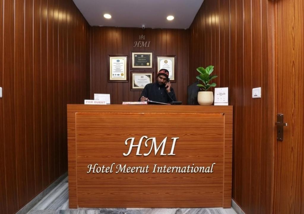 a man sitting at a hotel meant international counter at Hotel Meerut International in Meerut