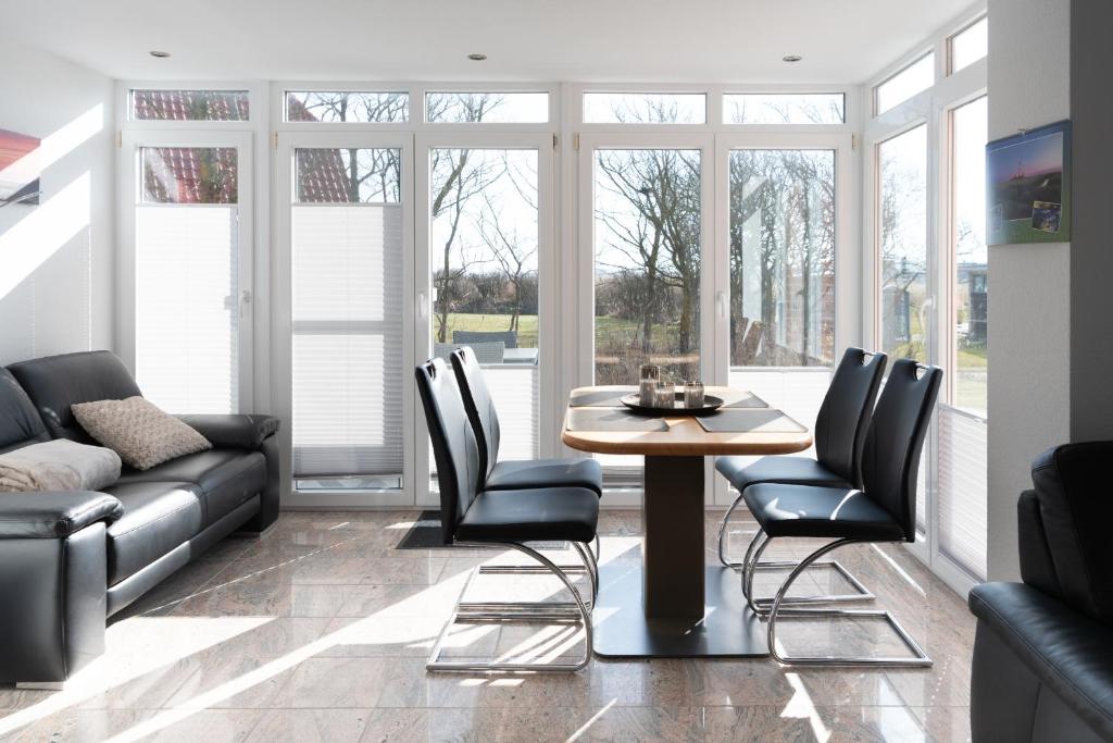 a living room with a table and chairs and a couch at Haus-Eriel-EG-rechts in Brösum