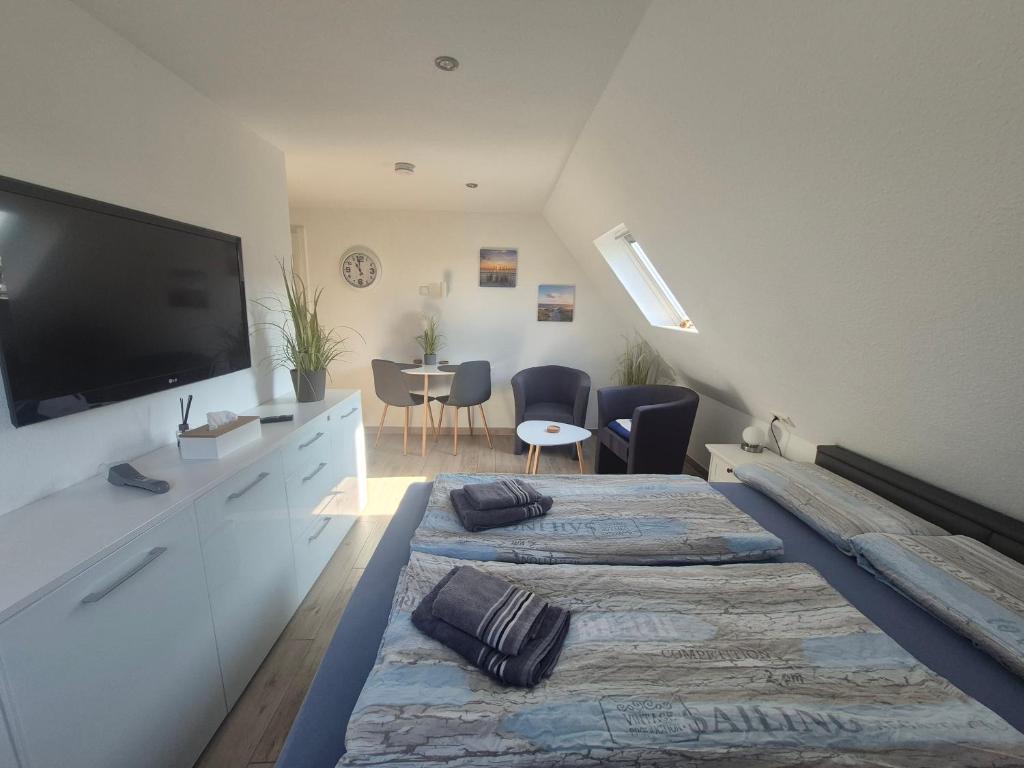 two beds in a room with a flat screen tv at Apartmenthaus Westerkoog in Hedwigenkoog