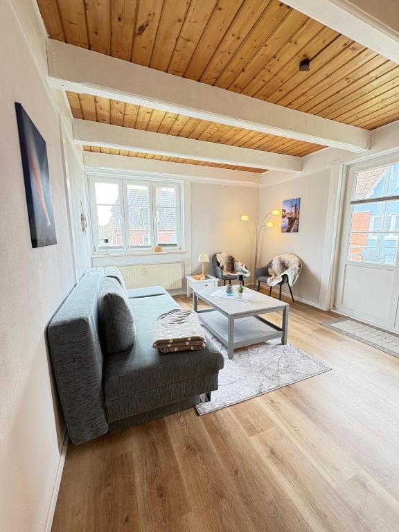 a living room with a couch and a table at Ferienwohnung Heimat auf Zeit Pellworm in Pellworm