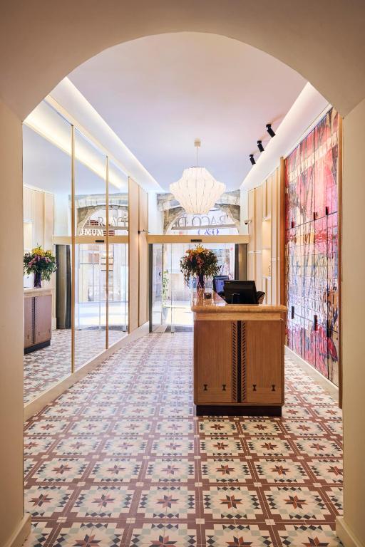 an open hallway with a lobby with a desk and windows at H10 Raco del Pi Boutique hotel in Barcelona
