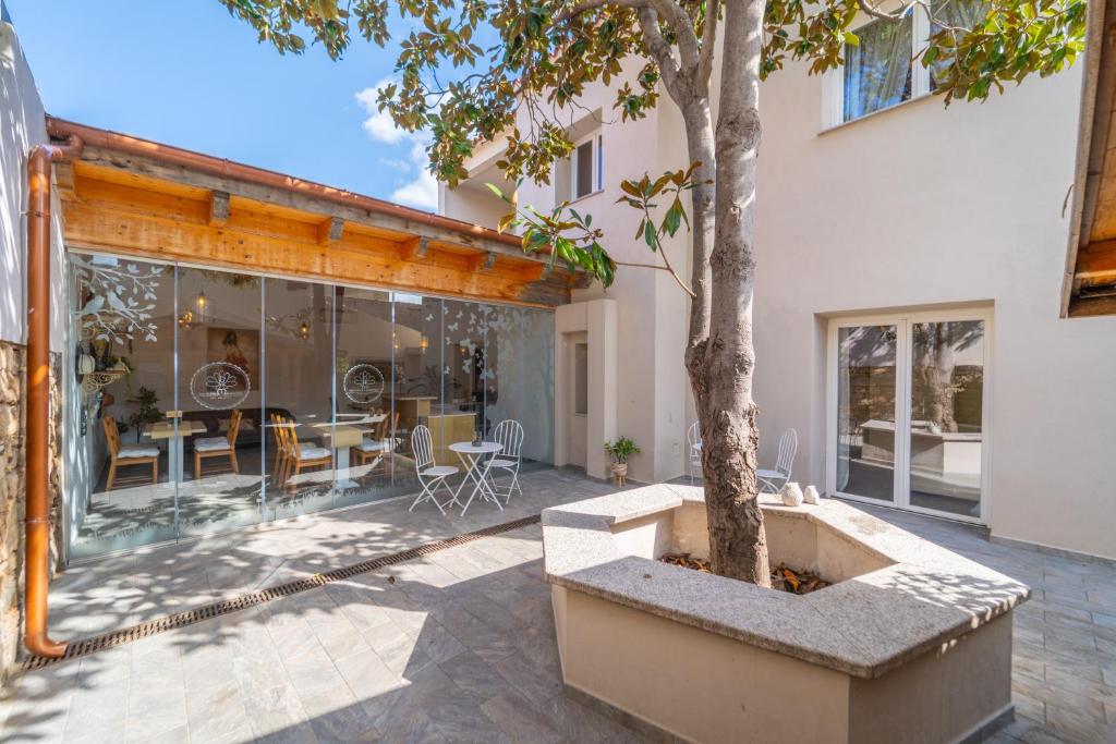 an outdoor patio with a tree and a building at Les Suites Magnolia in Olbia