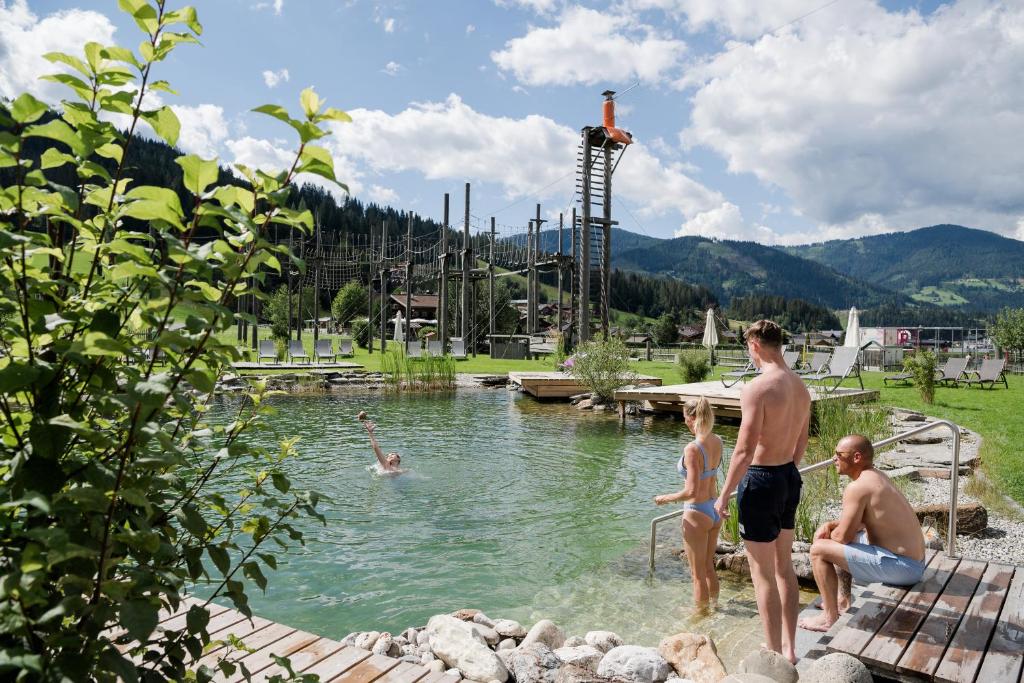 a group of people standing in a swimming pool at almlust - hotel, apartments, chalets in Flachau