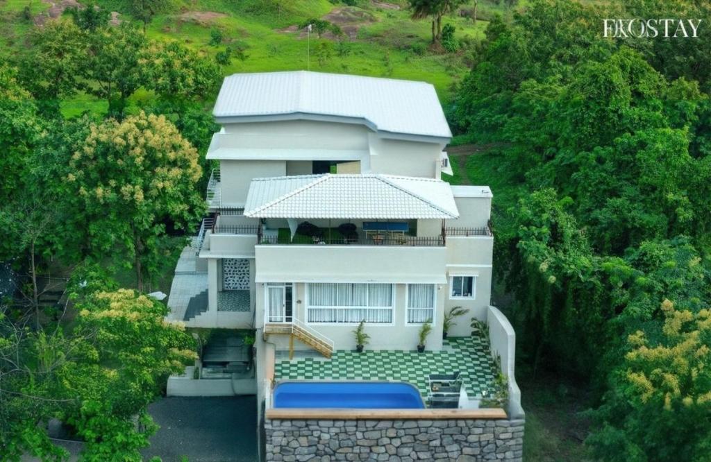 an aerial view of a white house with trees at EKOSTAY - Alpine Villa in Alibaug