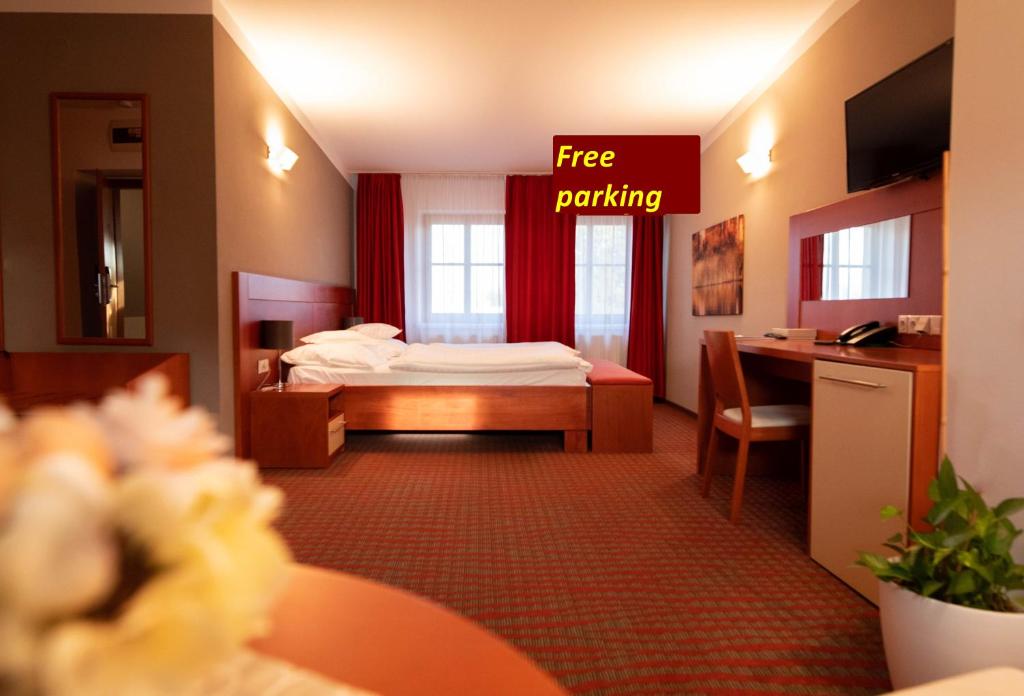 a hotel room with a bed and a desk at KATERAIN hotel, restaurace, wellness in Opava