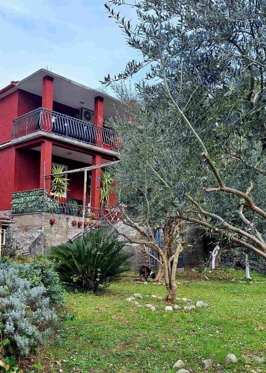 a red house with a balcony on top of it at Red House Apartment in Kotor