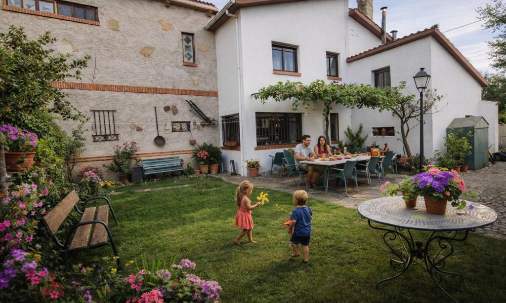 two children playing in the yard of a house at Casa Rural Ivanrey in Ivanrey