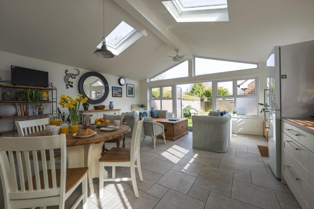 a kitchen and dining room with a table and chairs at Haven House in Lymington