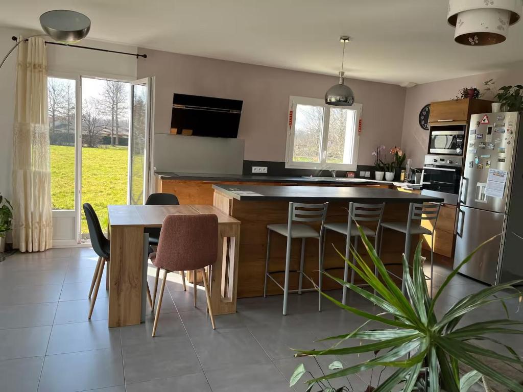 a kitchen with a island and a table with chairs at Maison de plain pied in Certines