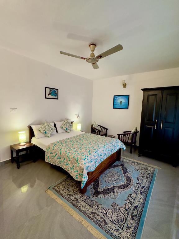 a bedroom with a bed and a ceiling fan at Green Castle in Gonikoppal