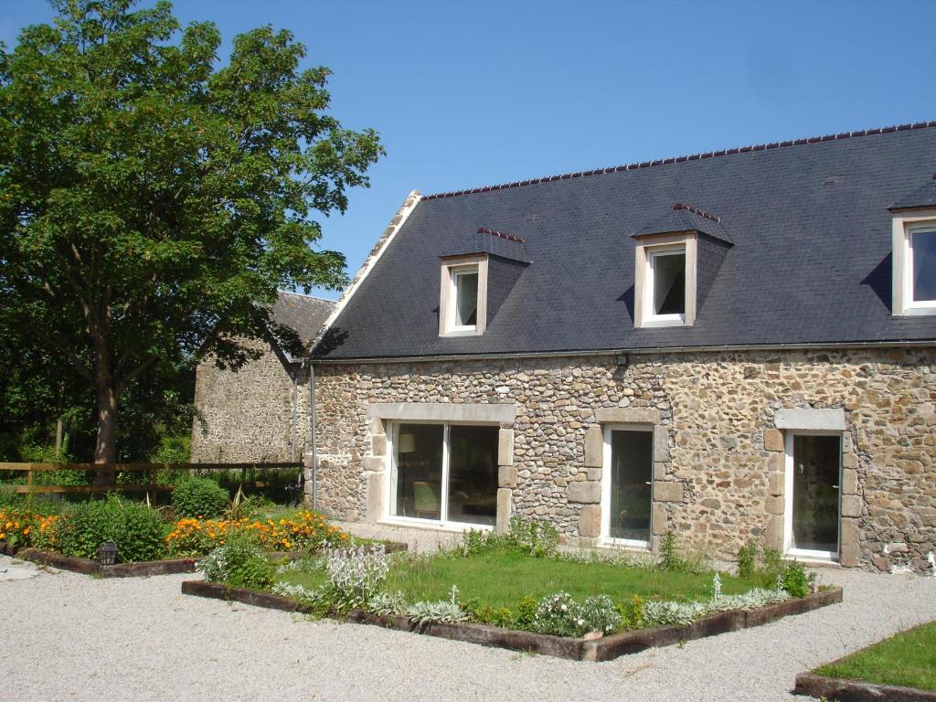 a stone house with a black roof at Gite de la Mare de la Trémaillerie in Blainville-sur-Mer