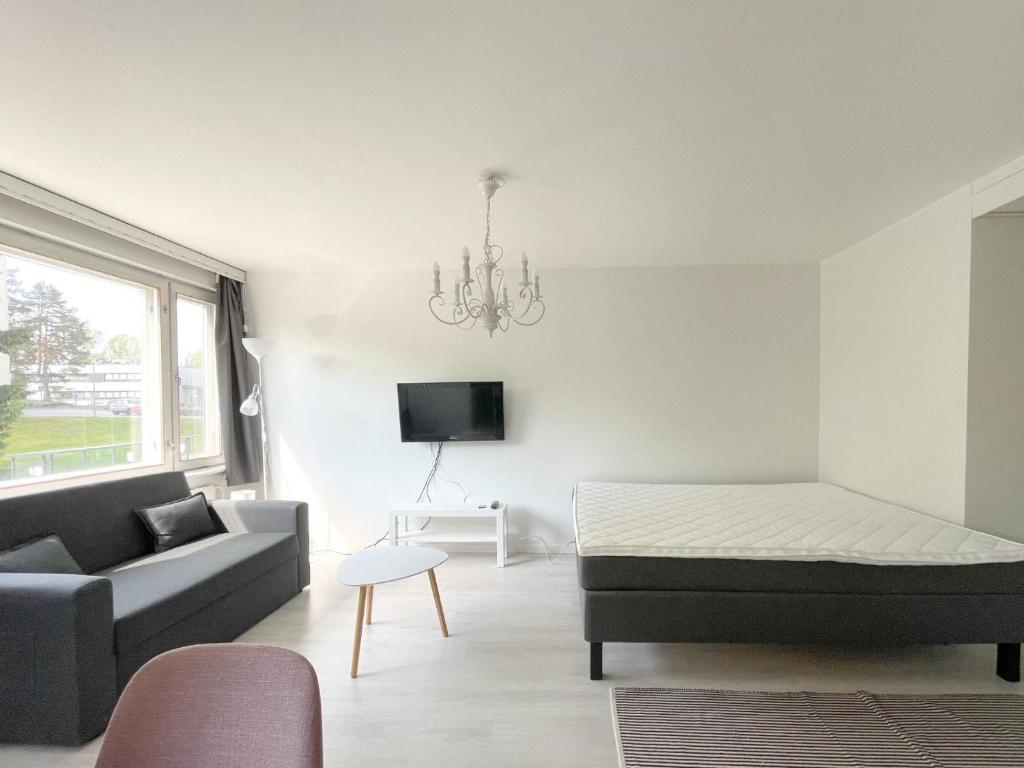a living room with a bed and a couch at Savonlinna City Apt Central in Savonlinna