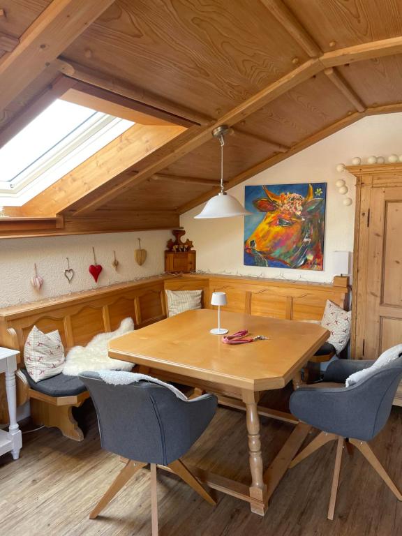 a dining room with a wooden table and chairs at Ferienwohnung Hörnernest in Bolsterlang