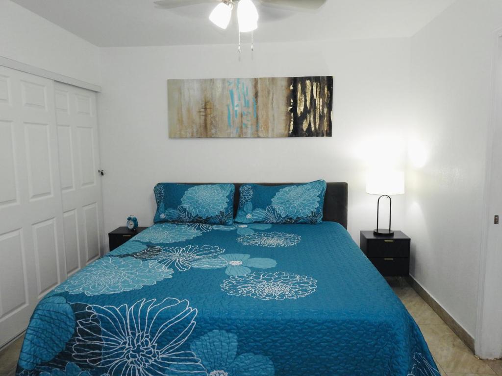 a bedroom with a bed with a blue comforter at AWESOME PLACe in Las Vegas