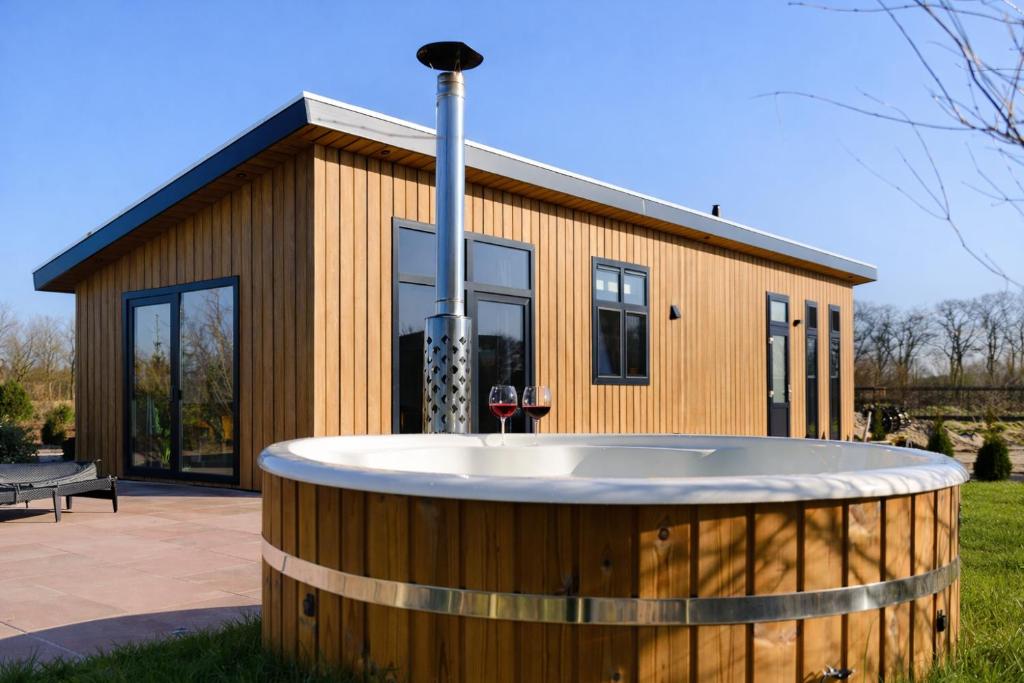 a building with a hot tub in front of it at Het Wellnesstje in Teuge