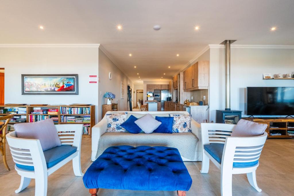 a living room with a white table with blue cushions at Seemeeu, Gouritsmond in Gouritzmond