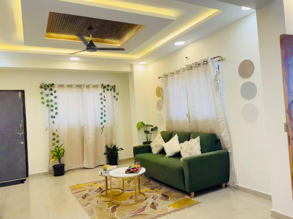 a living room with a green couch and a table at The Hampiness Studio 2 in Hospet