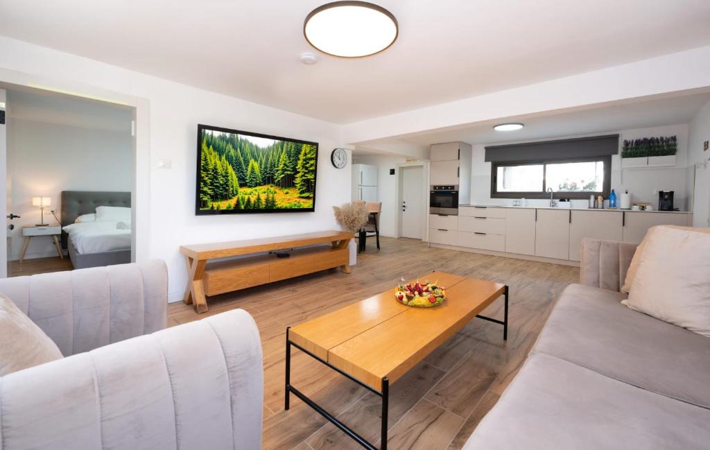 a living room with a couch and a table at לב המעיין- סוויטה מושלמת עם ג'קוזי במושב פסטורלי in Reẖov
