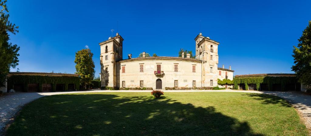 stary zamek z trawnikiem przed nim w obiekcie Ostello Castello Mina Della Scala w mieście Casteldidone