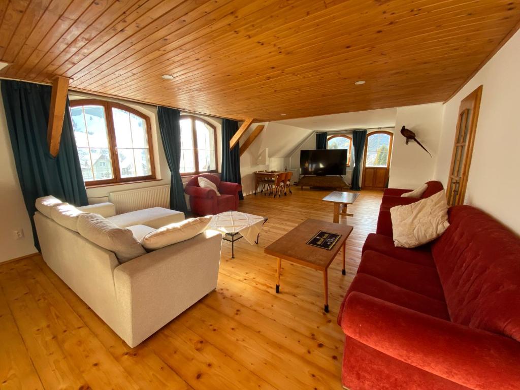 a living room with a couch and a table at Hunters Lodge in Liptovská Lúžna