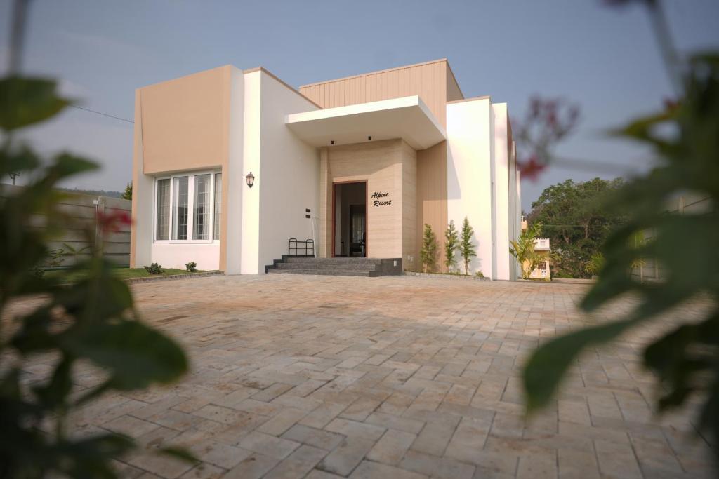 a large white building with a brick driveway at Alpine Resort in Yelagiri
