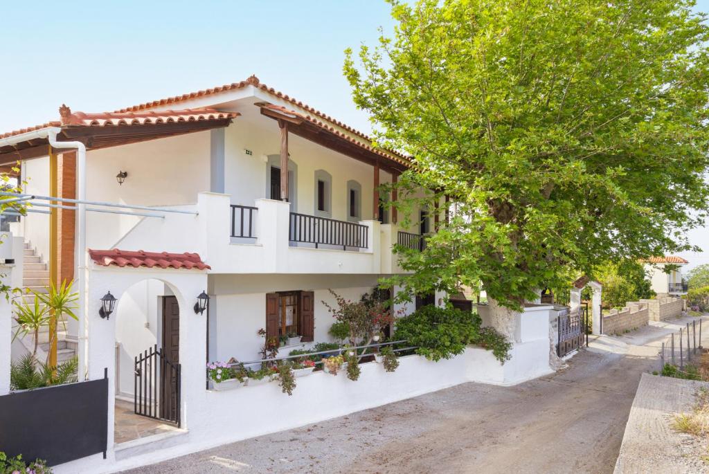 a house with white walls and a tree at Lagos House Α in Kámpos