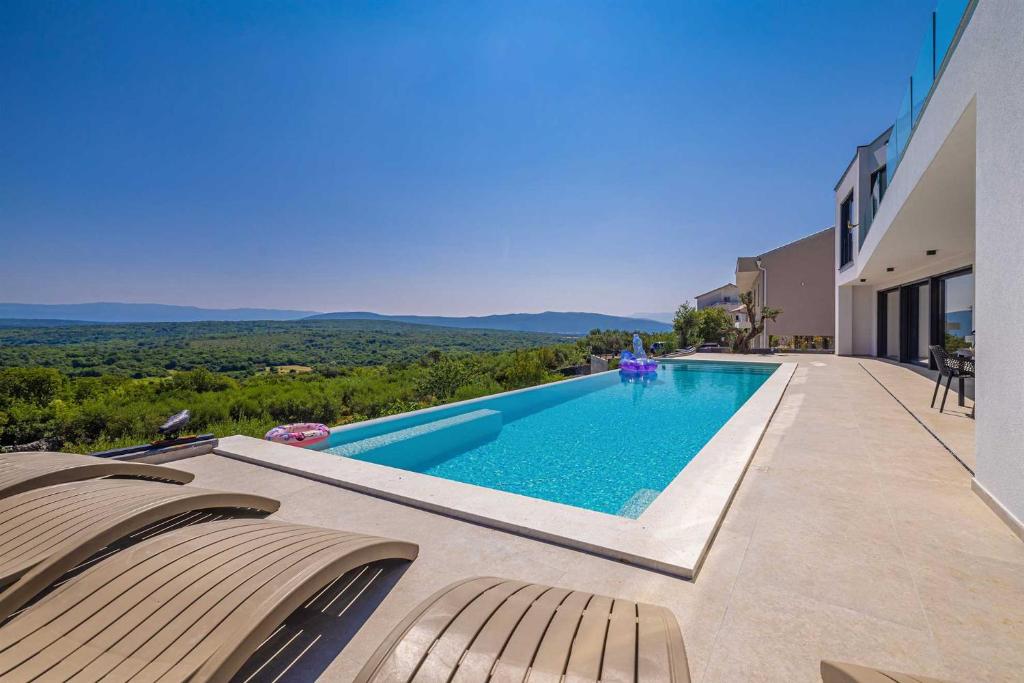 ein Swimmingpool im Hinterhof eines Hauses in der Unterkunft Villa ELEVATION in Vrh