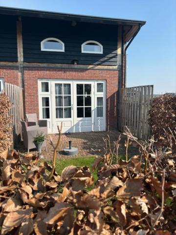 a brick house with a white door and a porch at De Citadel - de Weide in Markelo