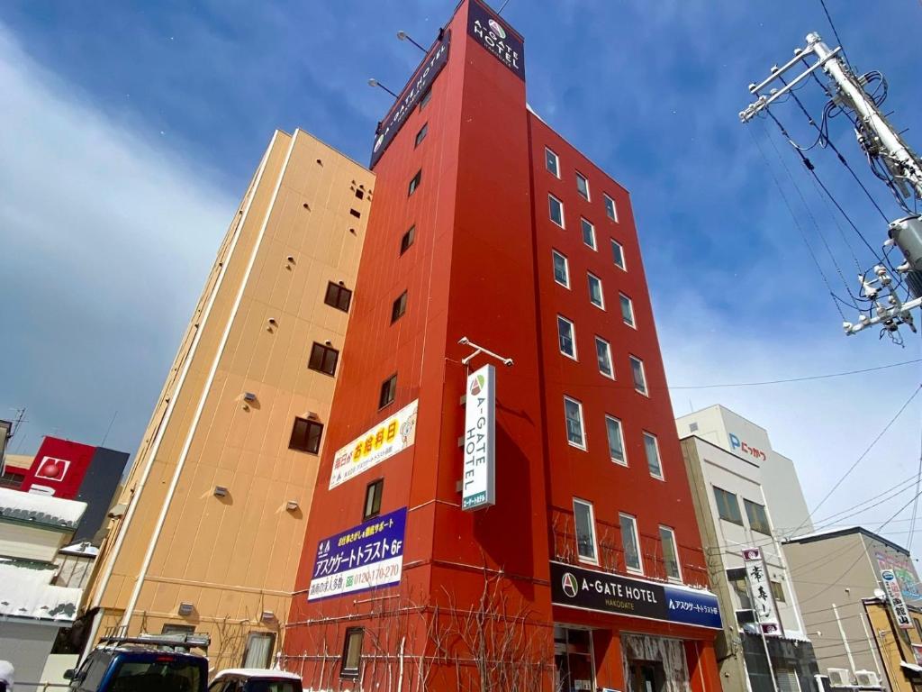 a red building in the middle of a city at A-GATE Hotel Hakodate in Hakodate