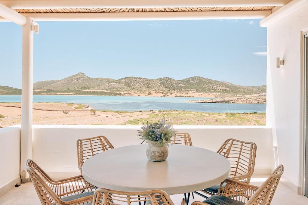 a table and chairs in a room with a view of the ocean at Antiparos Thea in Antiparos