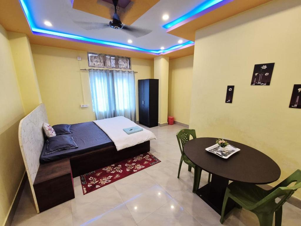 a room with a bed and a table and a ceiling at Nmck Homestay in Guwahati