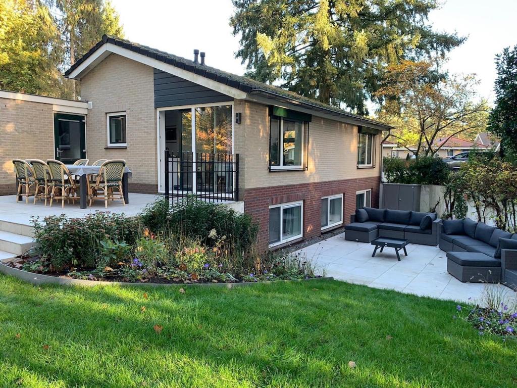 a house with a patio and a table and chairs at Villa Veluwe in Putten