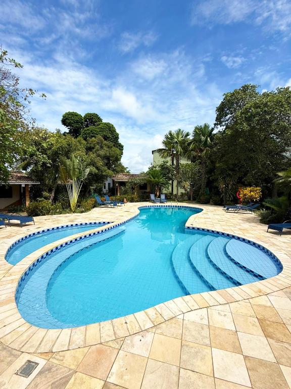 a swimming pool with blue water in a yard at Pousada Sol e Luna - Pipa Garden in Pipa
