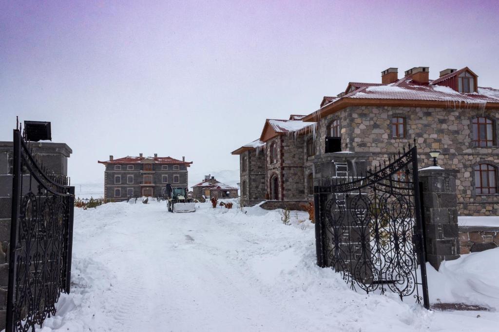 a gate in the snow next to some buildings at Lake Cildir Lodge in Çıldır