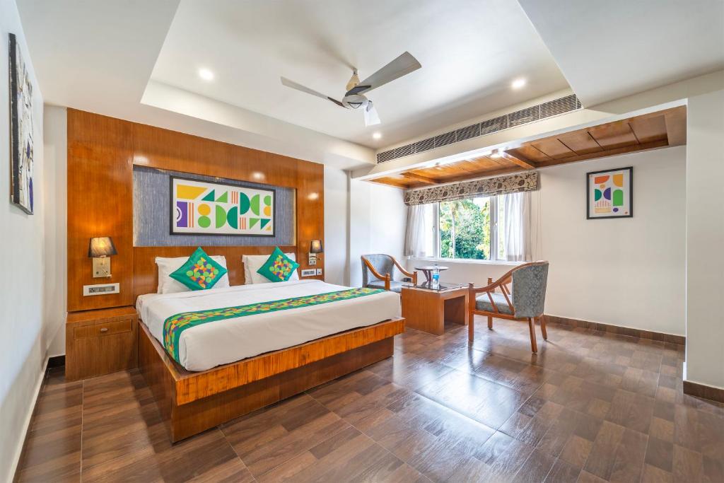 a bedroom with a bed and a desk in a room at Treebo New Indraprastha in Kilimanūr