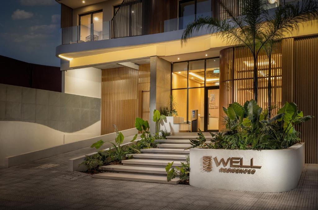 a lobby of a building with stairs and plants at WELL Residences - By AVA Rentals in Asunción