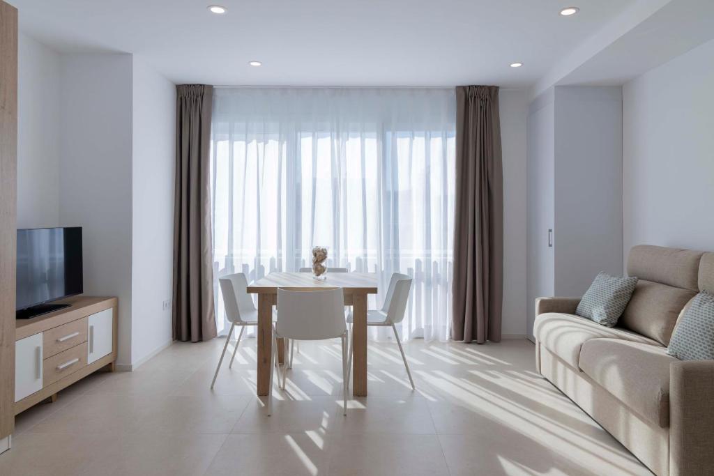 a living room with a table and a couch at Apartamentos Armonia Peñíscola in Peniscola