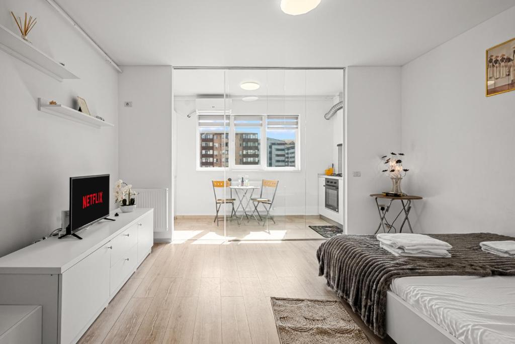 a white bedroom with a bed and a dining room at FLH - Cozy Heaven in Chiajna