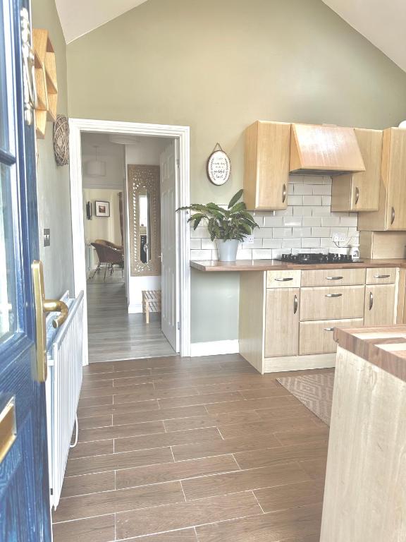a kitchen with wooden cabinets and a dining room at Newcastle Pet friendly 1 bed drive garden 10m city in Kenton