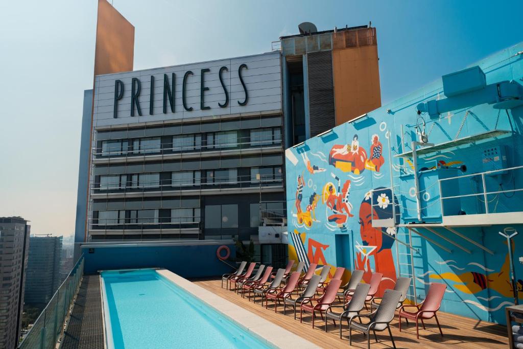 a swimming pool on the roof of a building with chairs at Barcelona Princess in Barcelona