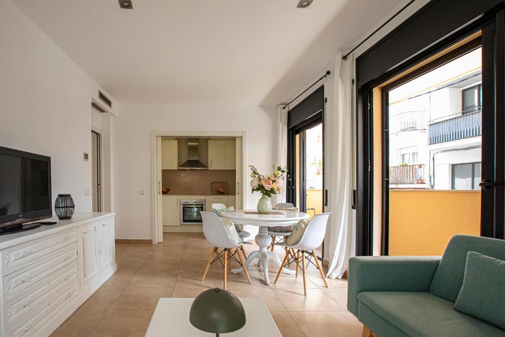 a living room with a couch and a table with chairs at INASS in Sitges