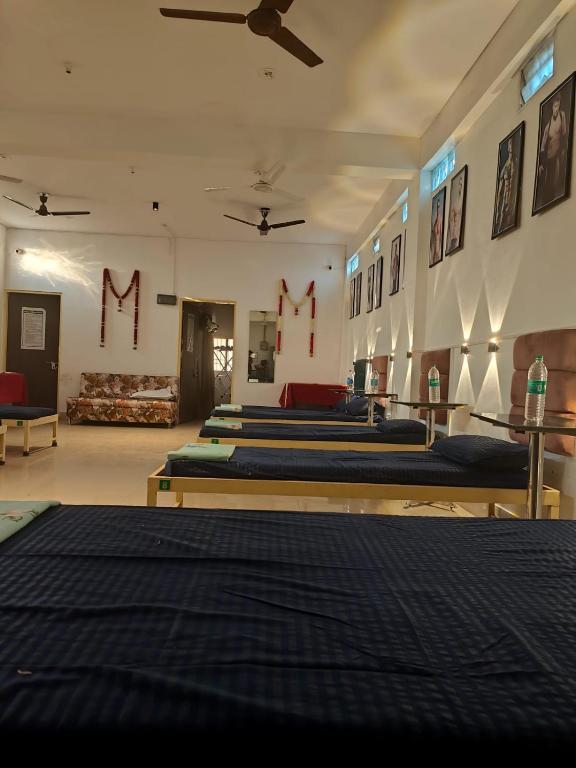 a group of beds in a room with m signs on the wall at Green bell male dormitory in Bhopal