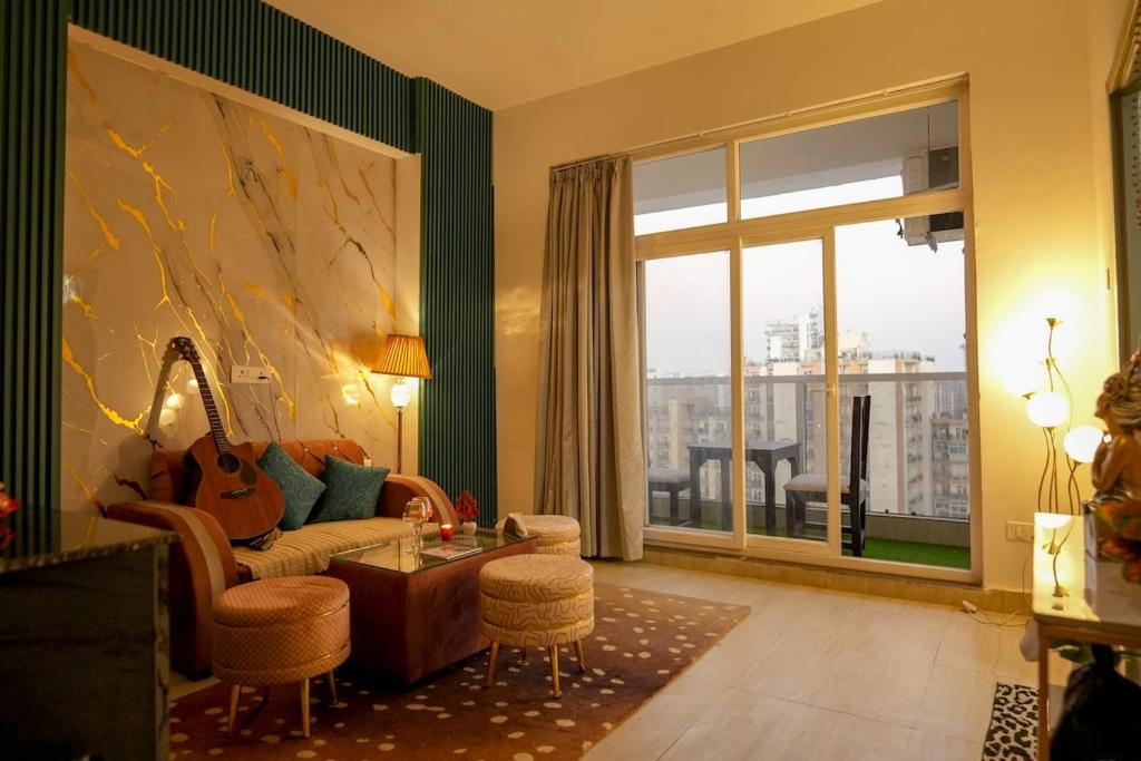 a living room with a couch and a large window at Spectrum Mall 1BHK Balcony Suite in Noida