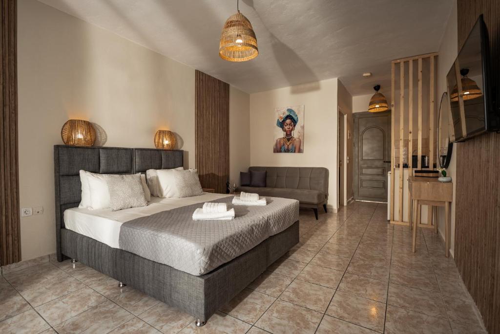 a bedroom with a large bed and a couch at Aggire Summer Suites in Alikanas