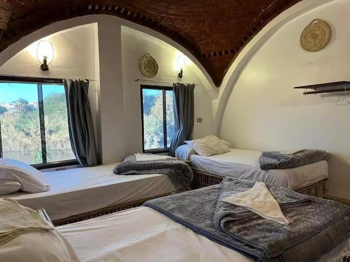 a room with four beds and a window at Turia Hotel in Aswan