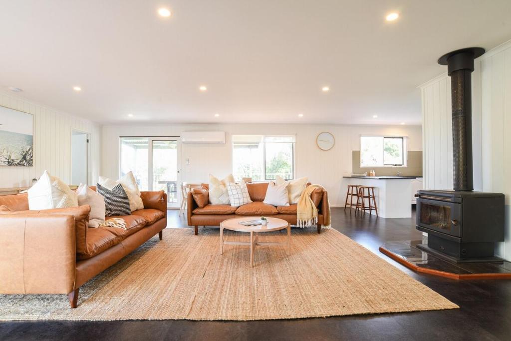 a living room with two couches and a stove at The Salt Shack in Mallacoota